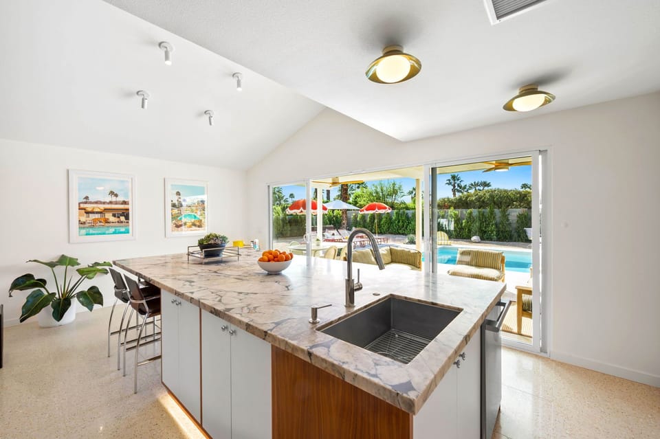 Your modern kitchen flows seamlessly to the pool terrace, where marble countertops and tropical views create the perfect setting for meals.