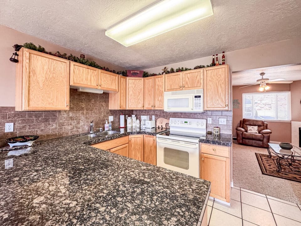 Well-appointed kitchen with granite countertops, ample cabinetry, and open view to living area
