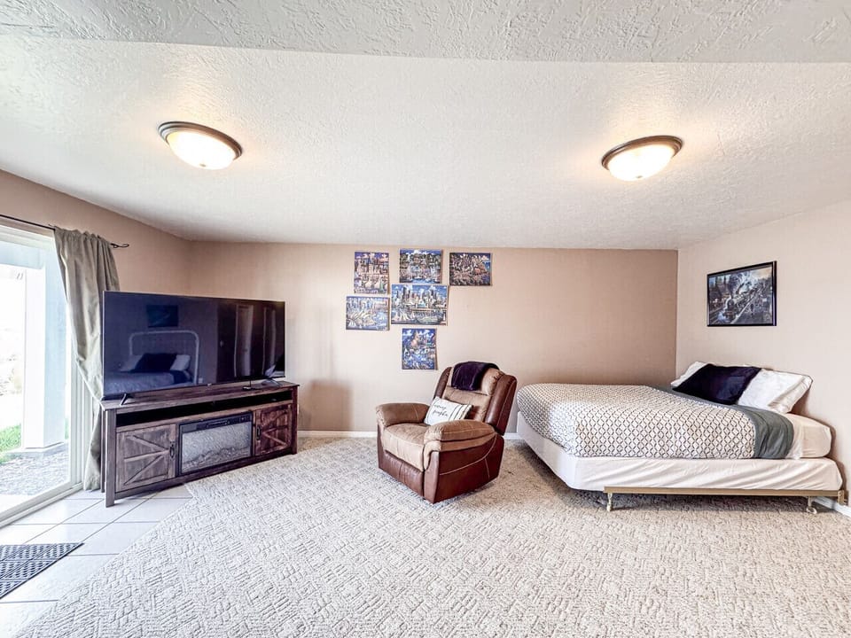 Open-concept sleeping and living space with TV, recliner, and patio access