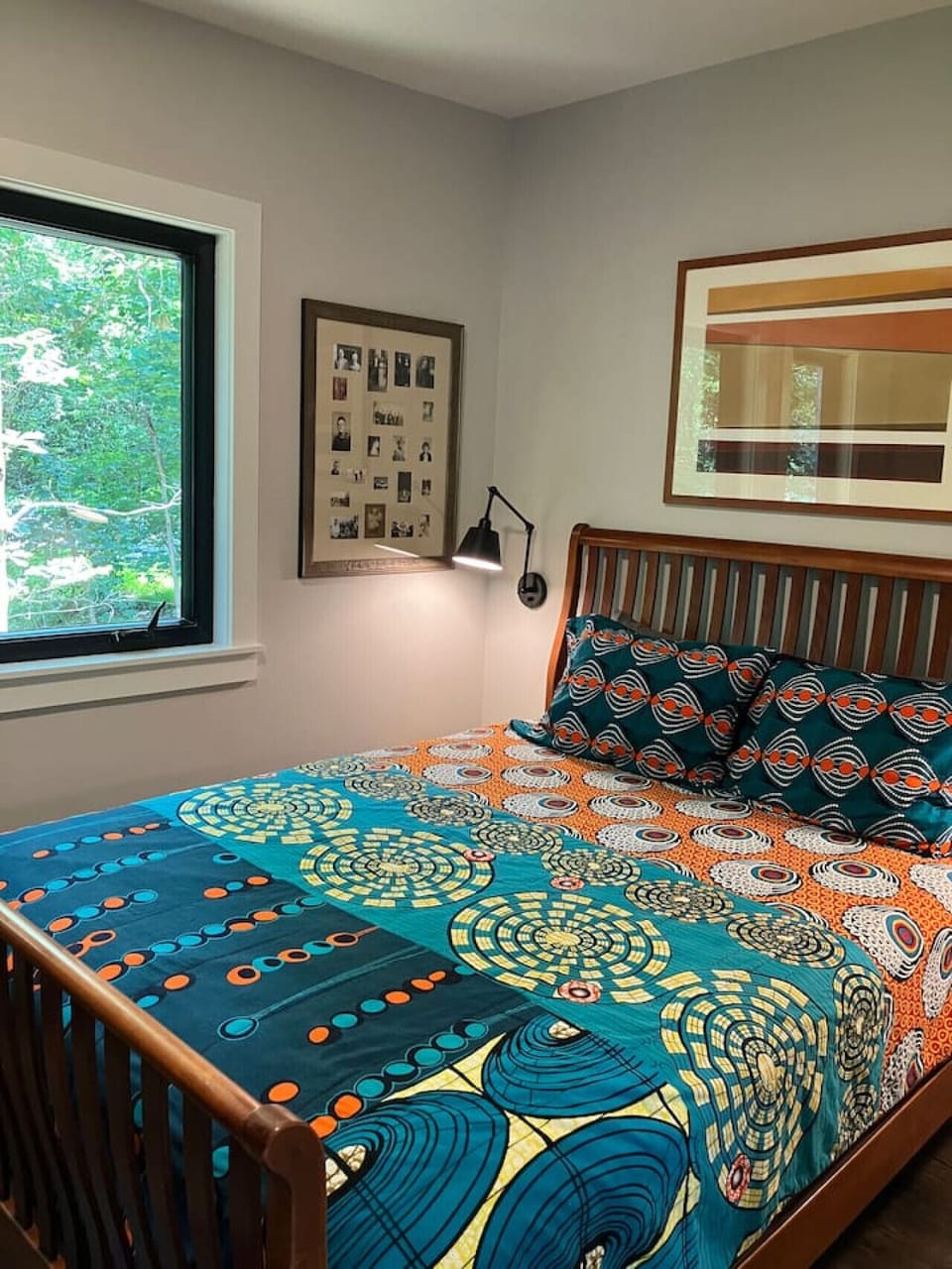 Rest easy in the cozy queen bedroom with soft light filtering curtains and tranquil forest views. Thoughtful storage includes a full size dresser and two spacious hanging cabinets. Mounted nightstands with reading lamps make it ideal for unwinding with a