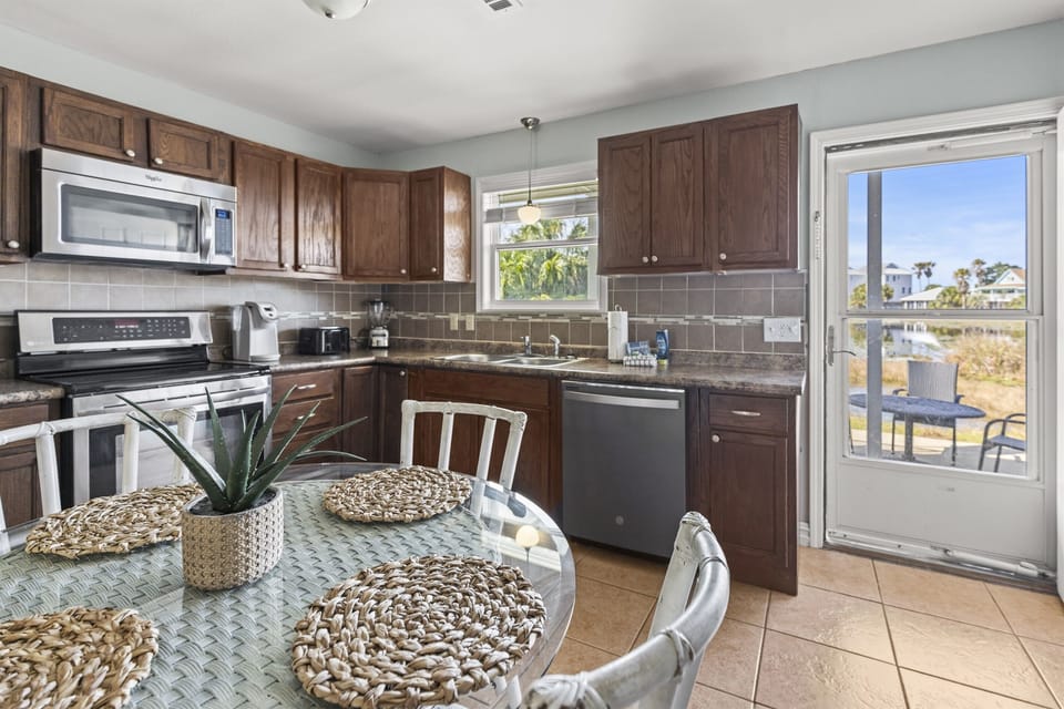 Your fully equipped kitchen features granite counters, stainless appliances, and opens to your private balcony with scenic views.
