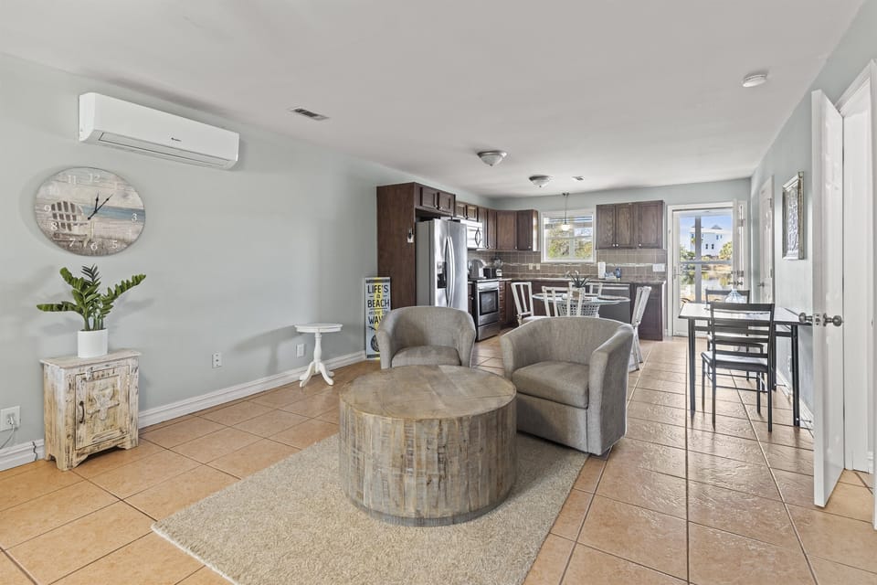 Your open-concept retreat features a fully equipped kitchen flowing into a comfortable living space with coastal charm and modern comfort.