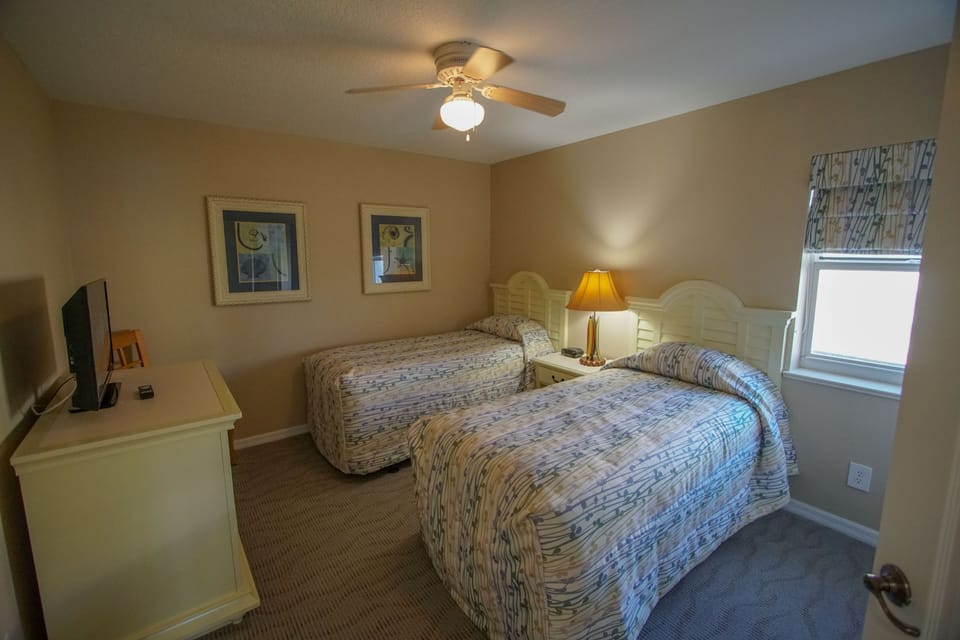 Cozy up in this bright bedroom featuring two comfy beds, perfect for relaxation after a day of sun.