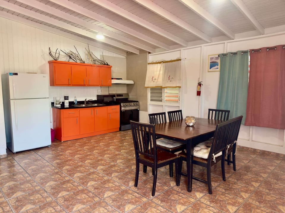 Cook up delicious meals in our fully equipped kitchen with vibrant orange cabinets.