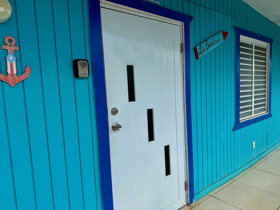 Colorful beach house entrance with a bright blue facade.