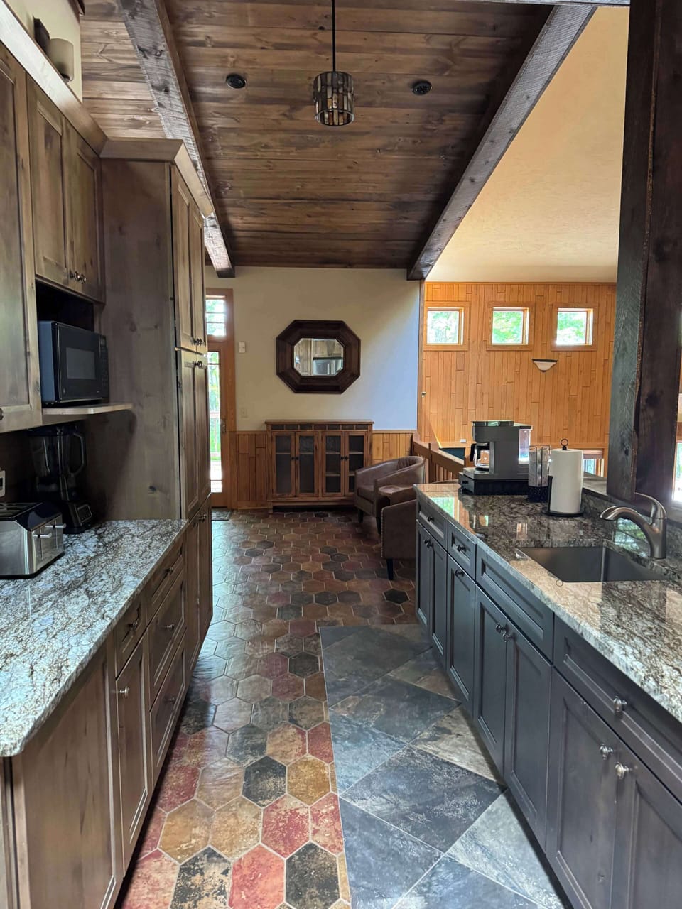 View from gourmet eat-in kitchen of coffee bar, 2nd farm sink, and lots of counter space looking forward towards the sitting room connecting to the screened in porch and wrap around deck & BBQ area for the Peninsula Lakehouse.