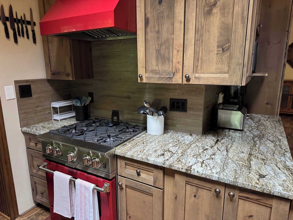 View of gourmet eat-in kitchen with gas stove top & oven within the Peninsula Lakehouse.  This is a bi-level open floor plan with continuous views of the lake and follows the contour of the lots' peninsula shoreline.
