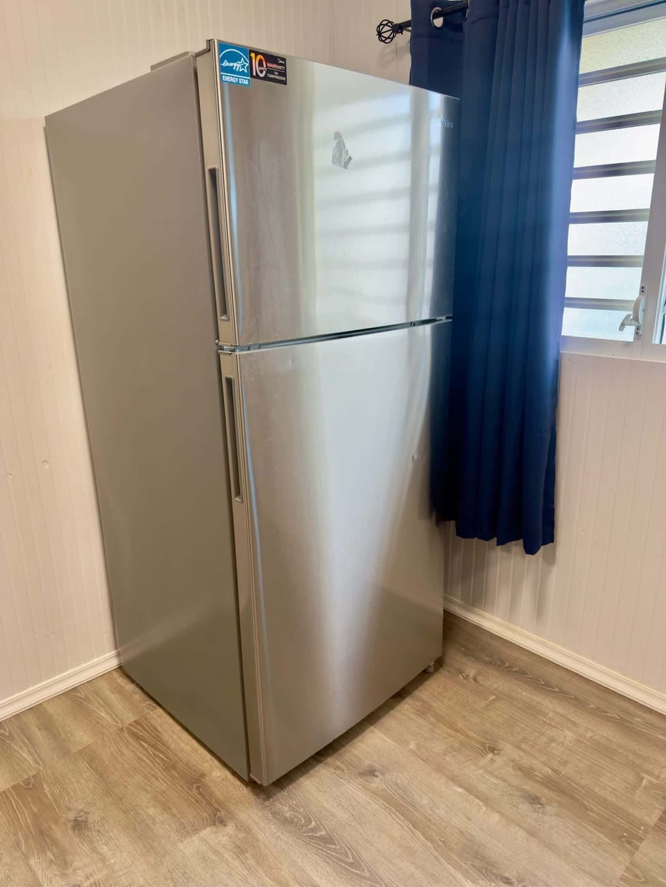 Full kitchen with stainless steel fridge.