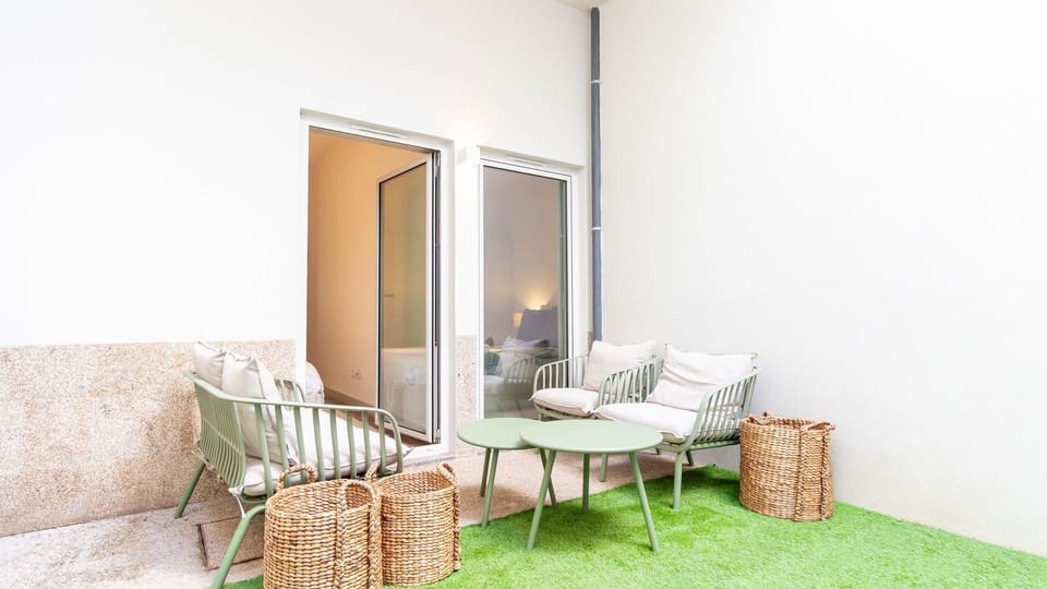 Step directly from your apartment onto this inviting private patio, where comfortable outdoor seating and artificial turf create a refreshing oasis perfect for enjoying a quiet morning coffee or an evening aperitif under the open sky.
