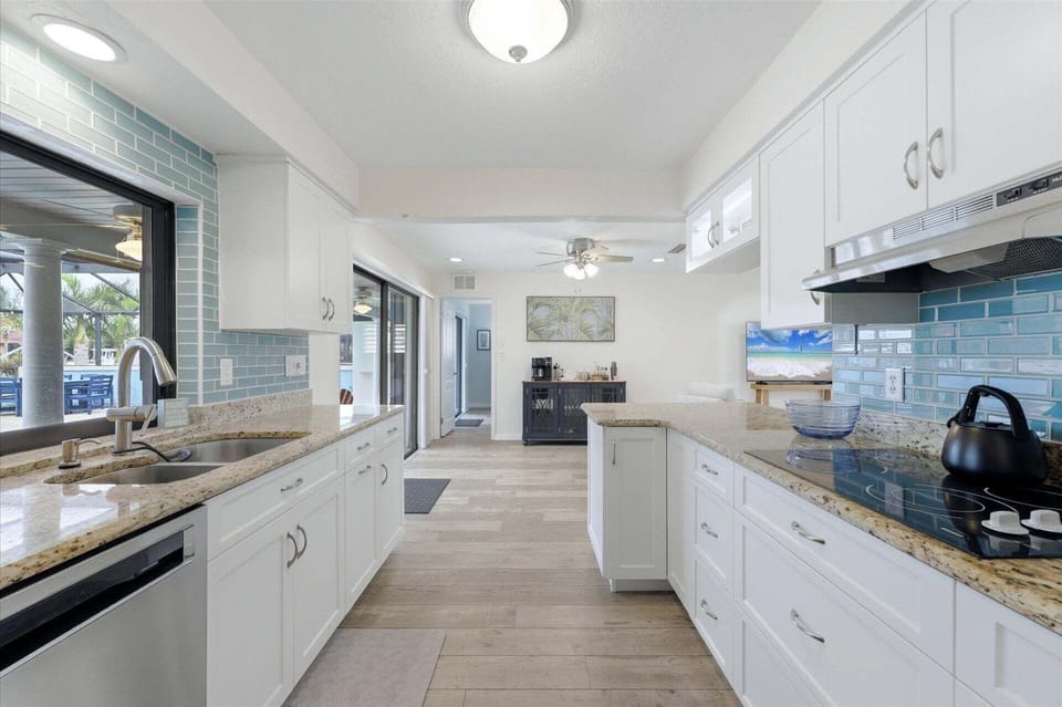 Bright, fully-equipped kitchen overlooking the pool and canal