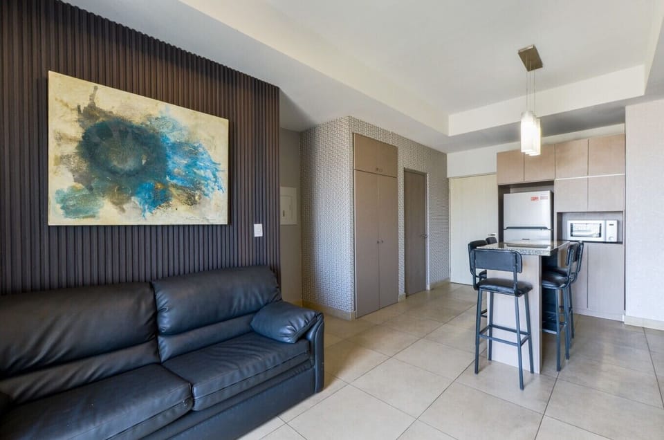 Sala principal con aire acondicionado, Smart TV, sofá cama, balcón y mueble de TV. Un espacio cómodo y fresco para relajarte y disfrutar.