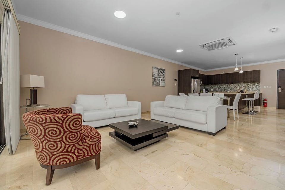 Step into a living room designed for comfort and convenience. A spacious, plush couch invites you to sink in and unwind after a long day.