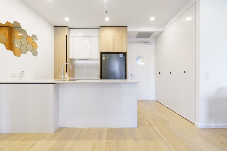 Sleek and modern kitchen featuring quality appliances and plenty of bench space for preparing meals at home.