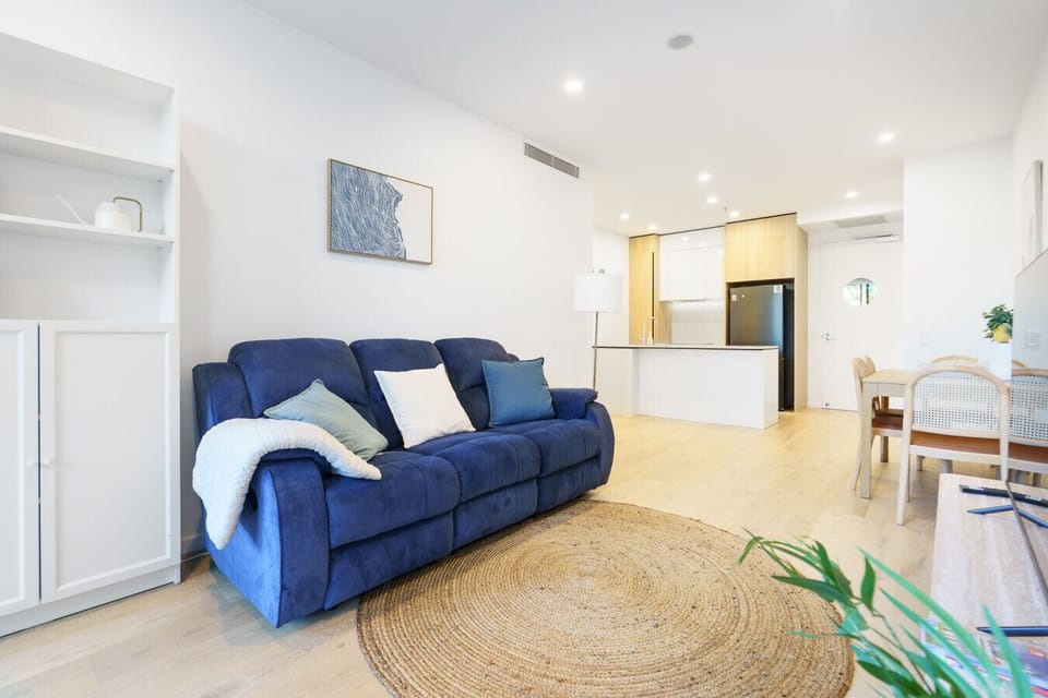 Relax on the comfy lounge after a day exploring, with plenty of natural light streaming through the apartment.
