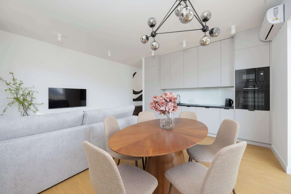 Dining area with wooden table and upholstered chairs in open space
