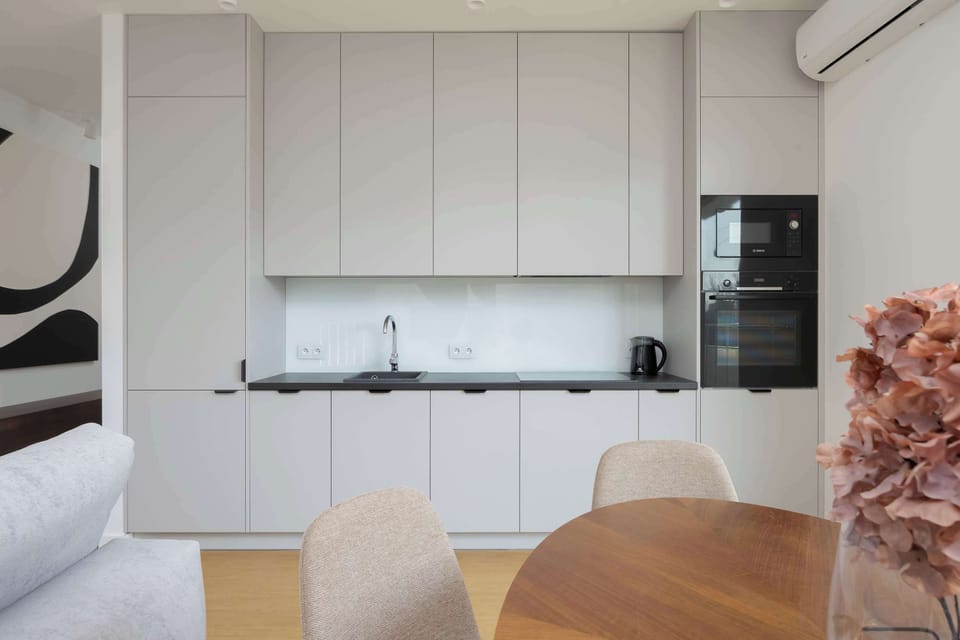 Compact white kitchen with built-in appliances and sleek cabinets
