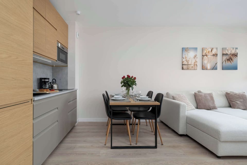 A view from the living room to the dining area and kitchenette, highlighting the apartment’s spaciousness and ample natural light.