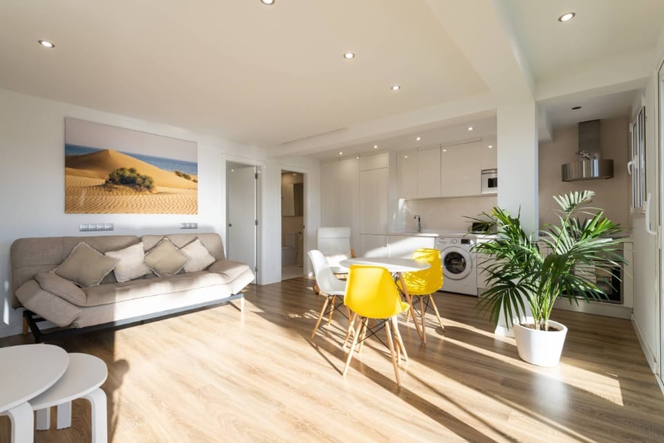 Bright living room with comfortable sofa and dining table, perfect for relaxing and enjoying meals in the apartment