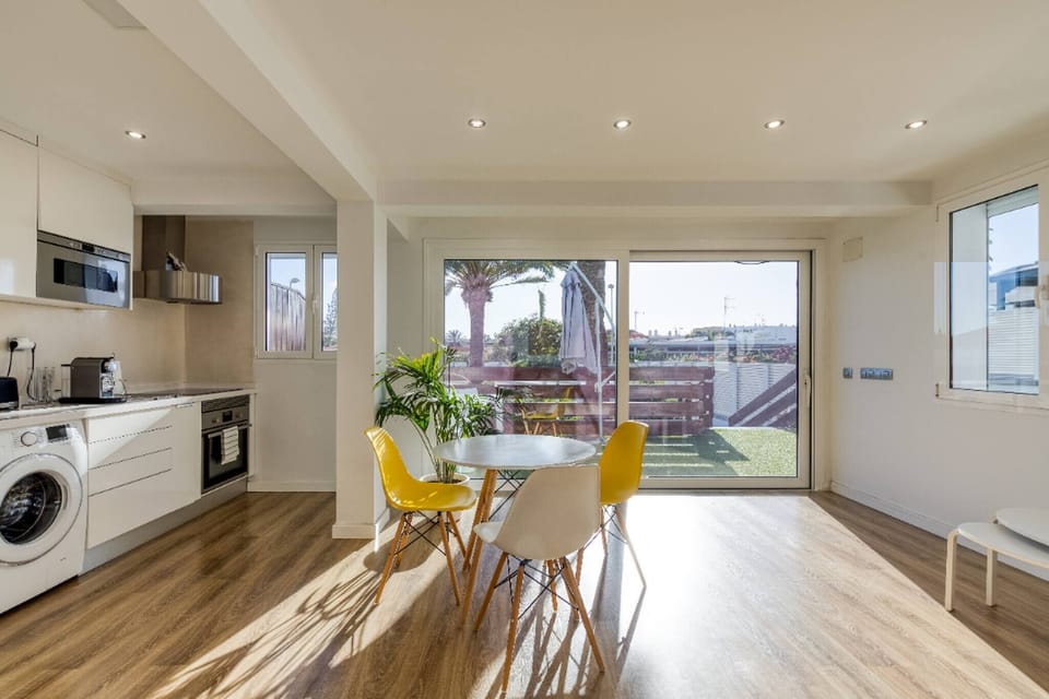 Dining area with table and chairs, partial view of the equipped kitchen and private terrace