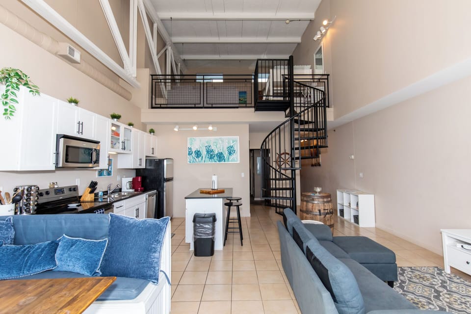 Step into your stunning loft with soaring ceilings, a sleek spiral staircase, and an open-plan design perfect for relaxing.