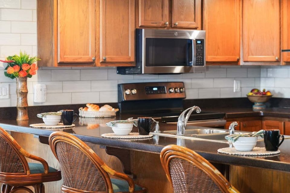 Fully equipped kitchen amenities including a stainless steel microwave and glass-top range, designed for easy vacation meal prep.