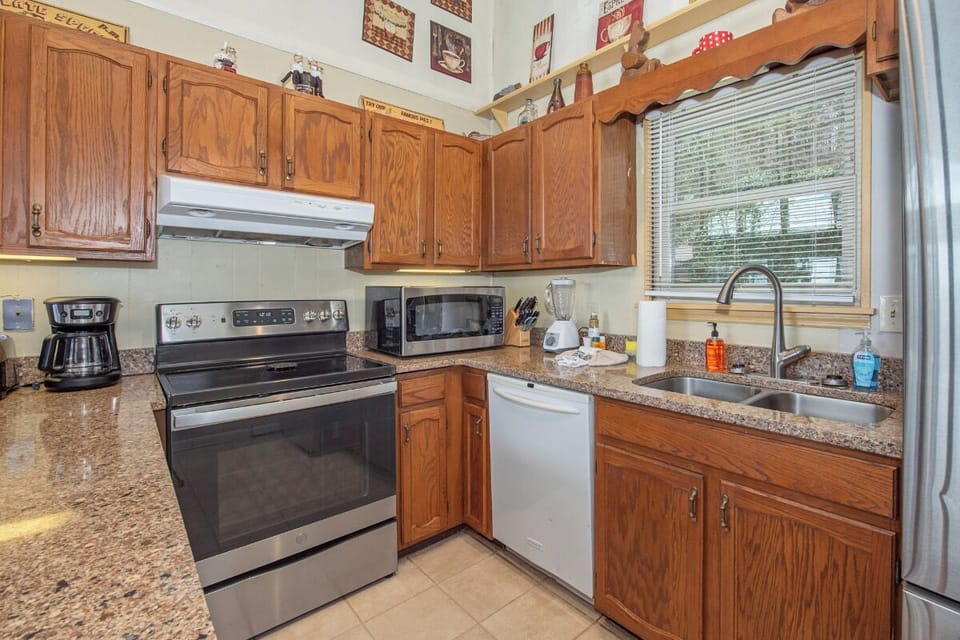 Your fully equipped kitchen awaits with granite counters, stainless appliances, and warm wood cabinets.