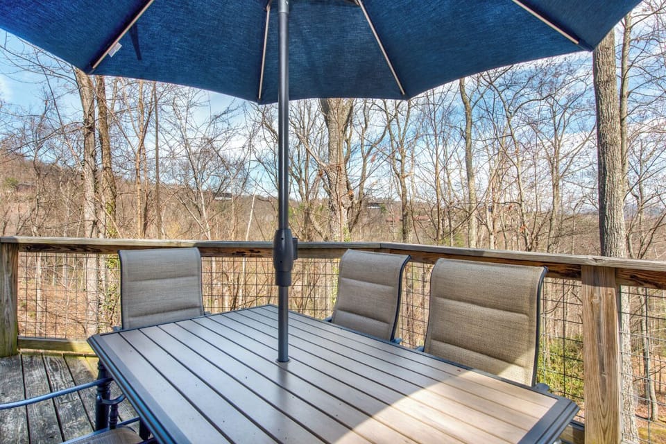 Dine al fresco on your private deck, shaded by an umbrella while enjoying peaceful woodland views through the trees.