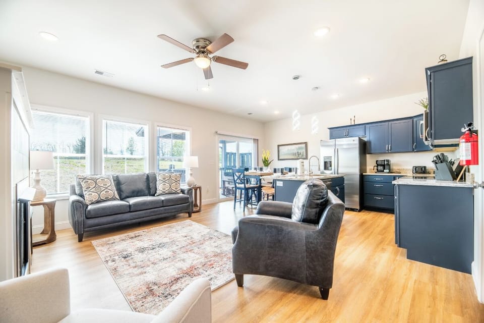 Relax in your stylish open-concept living space with modern kitchen, cozy seating, and warm wood floors.