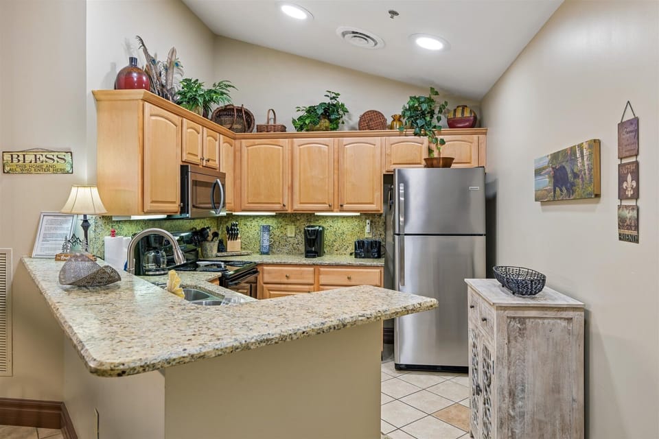 Prepare delicious meals in your fully equipped kitchen featuring granite counters, stainless appliances, and charming decorative touches.