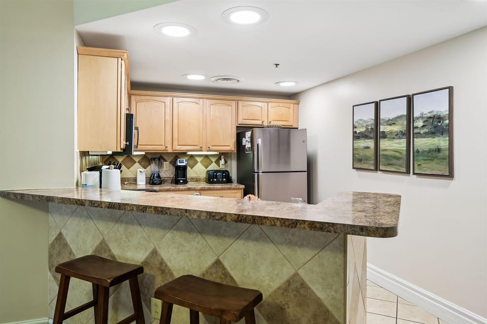 Your fully equipped kitchen features granite counters, stainless appliances, and breakfast bar seating—perfect for preparing meals and casual dining together.