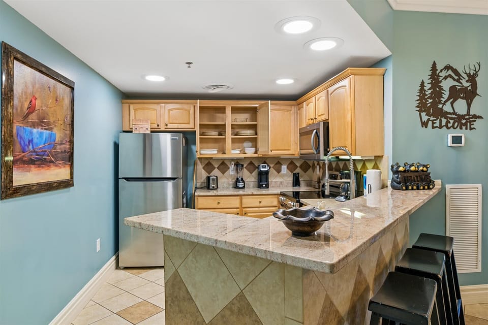 Your fully equipped kitchen features granite countertops, stainless steel appliances, and a breakfast bar where you can sip morning coffee.