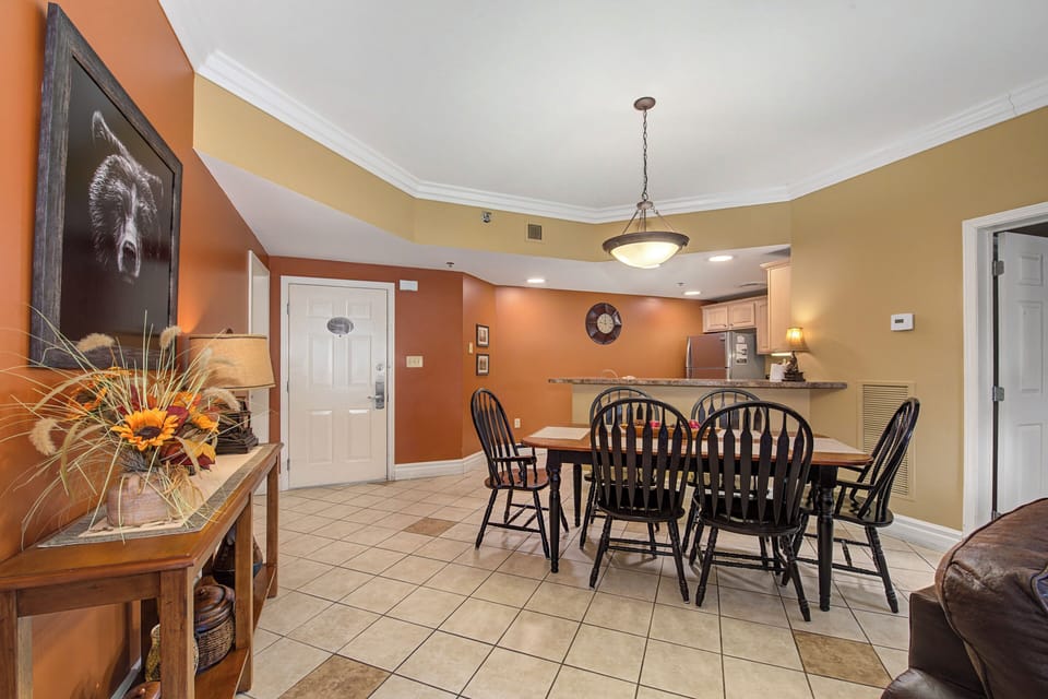 Your open dining area invites family meals with warm wood chairs around a spacious table, connected to your fully equipped kitchen.