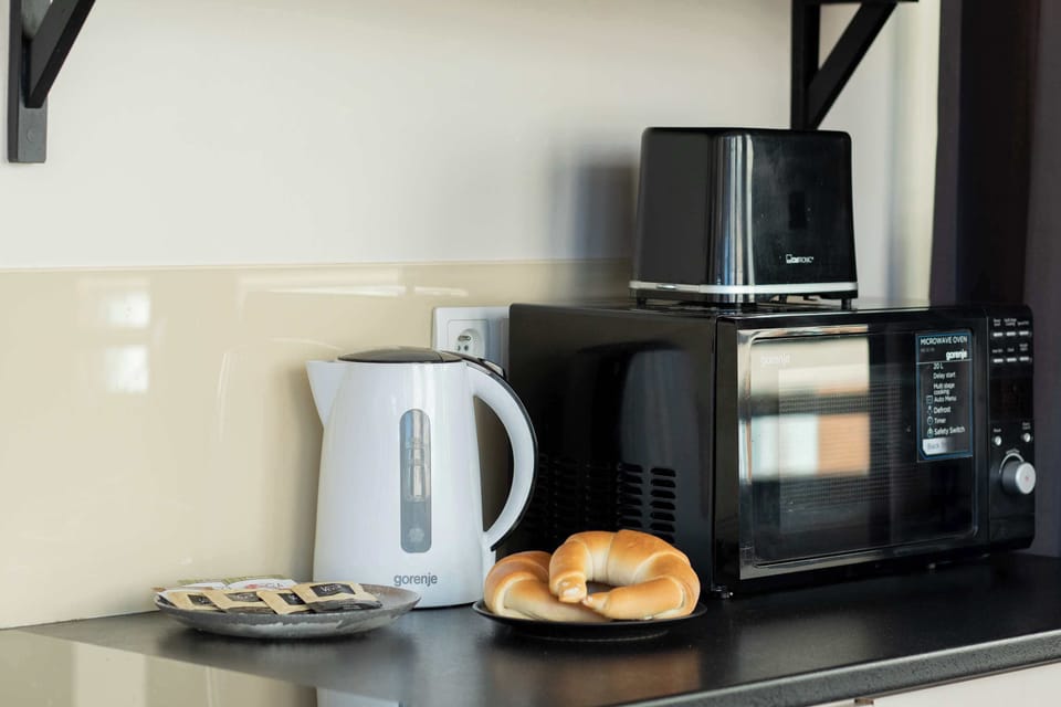 A close-up of a kitchen corner with a kettle and coffee machine. The setup is convenient for preparing drinks.