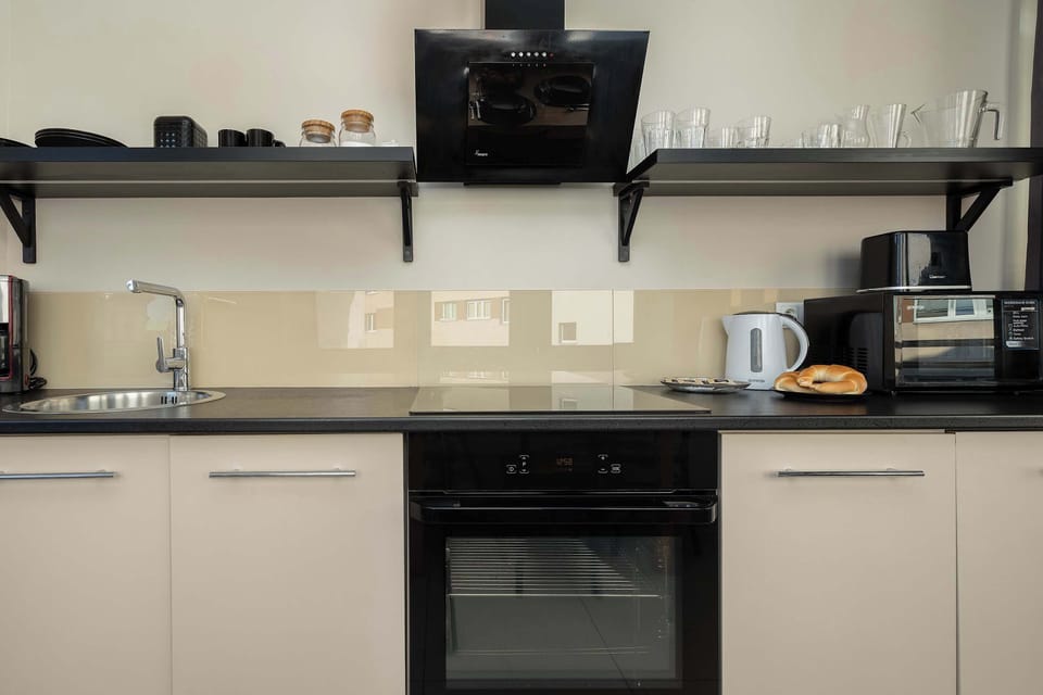 A close-up of the kitchen workspace with an oven, stovetop, and cabinetry. Clean lines and neutral tones give it a modern feel.