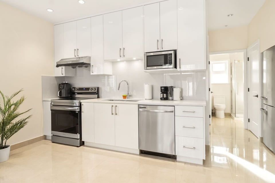 Kitchen with coffee machine, kettle, and basic cooking essentials.