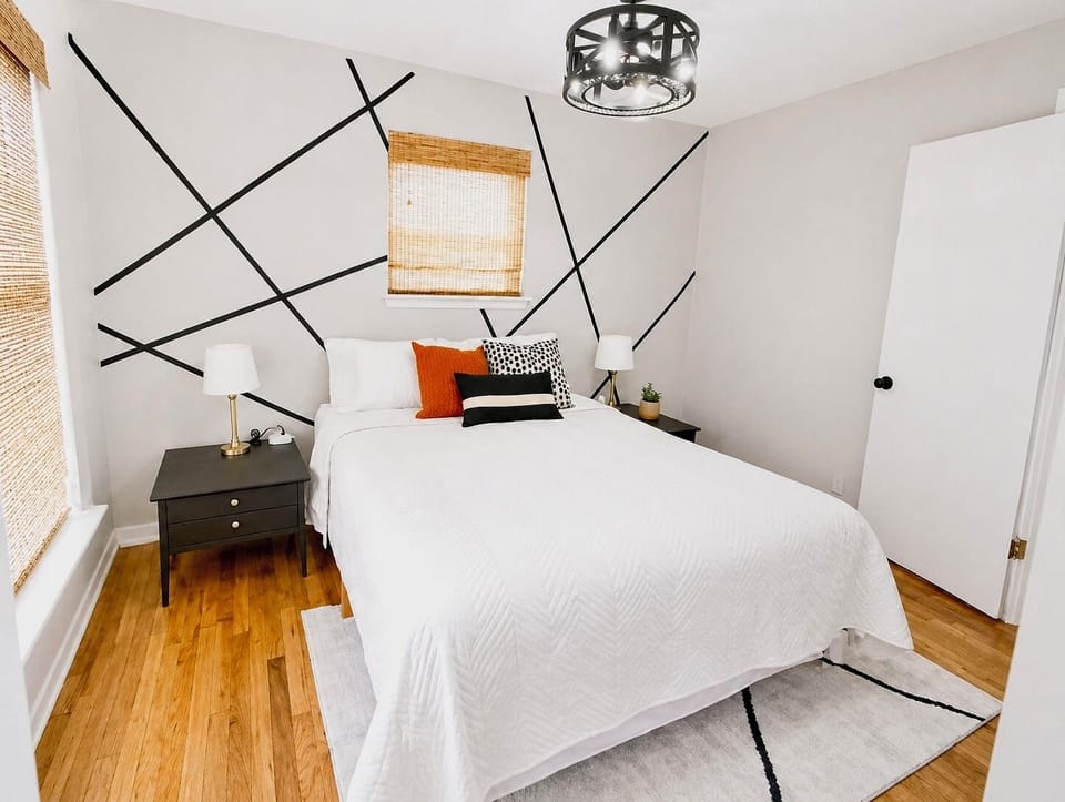 Queen bedroom with clean, modern design, overhead ceiling fan