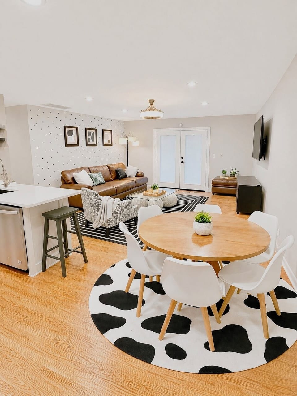 Spacious living room with an oversized leather sofa, chairs and 65in Roku TV