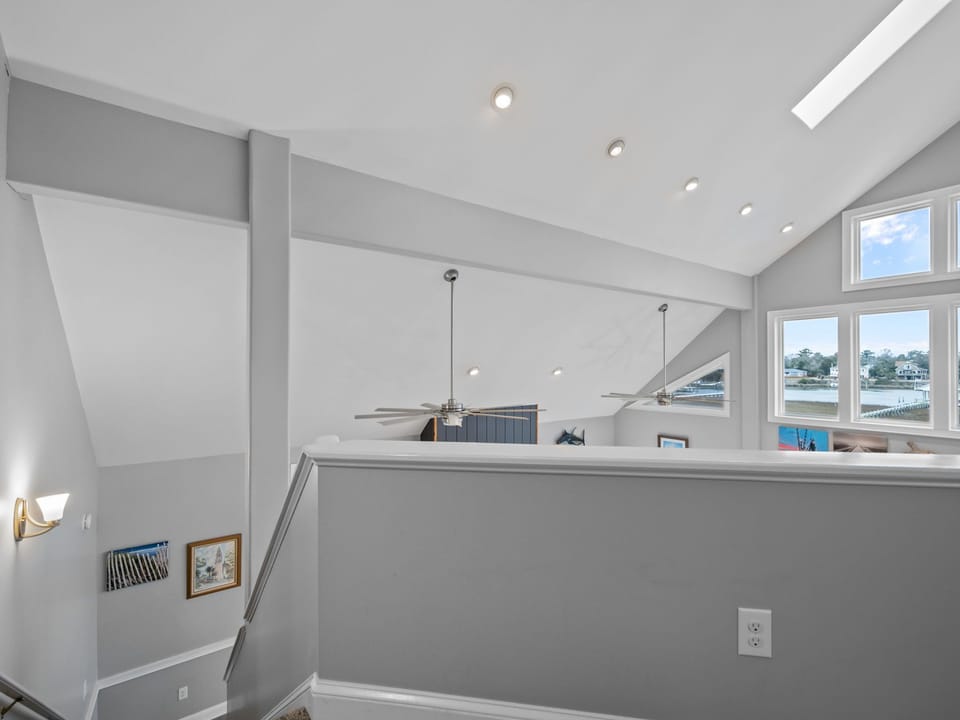 Bright open loft space with soaring ceilings and waterfront views through expansive windows.