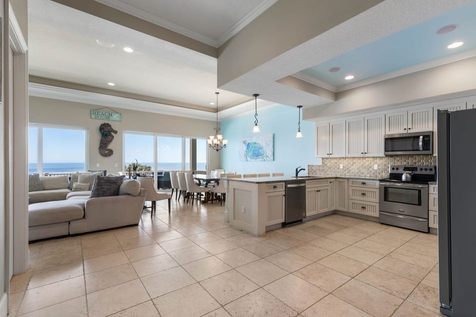 Morning light spills across the kitchen as coffee brews, kids drift toward breakfast, and the ocean glows beyond the balcony. Here, slow family mornings turn into beach days, shared meals, and the kind of memories everyone talks about for years.