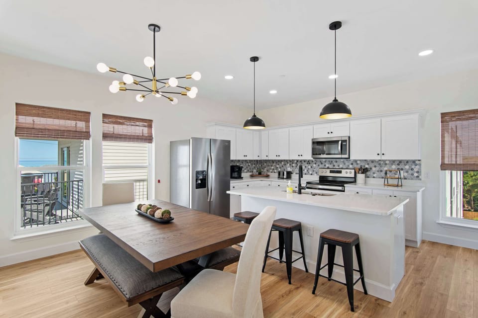 Your modern kitchen flows seamlessly into the dining area, where stylish pendant lights illuminate shared meals and the breakfast bar invites morning coffee.