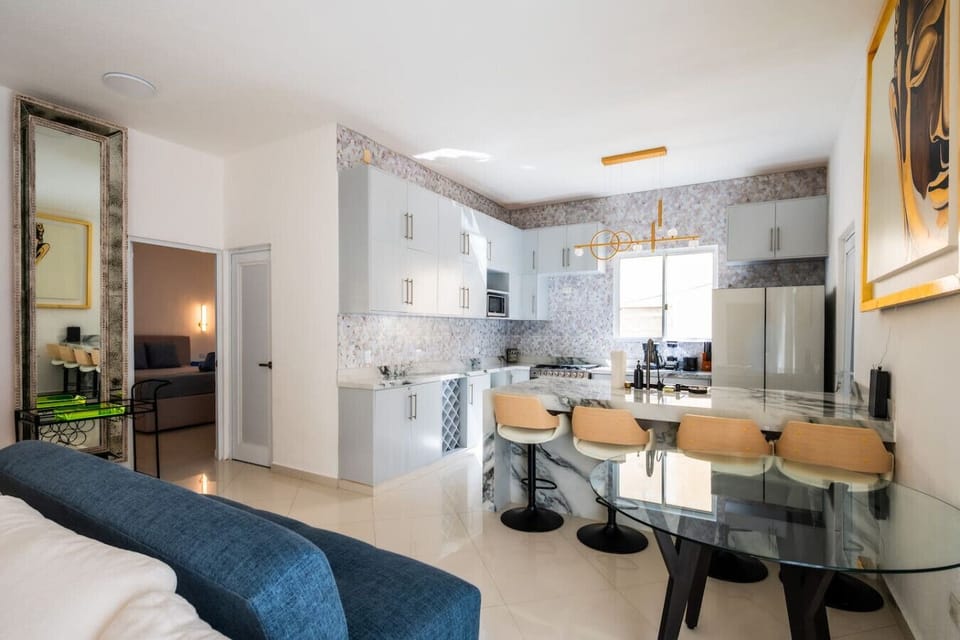 Modern kitchenette with natural touches and soft lighting — ideal for enjoying breakfast before heading to the beach.