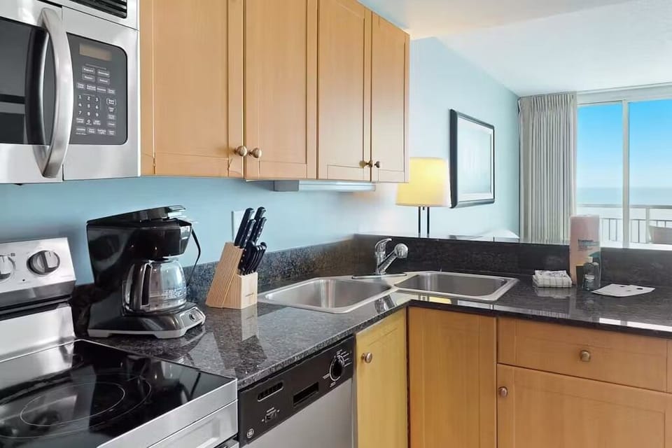 Modern beach condo kitchen! Stainless steel appliances, granite counters, 