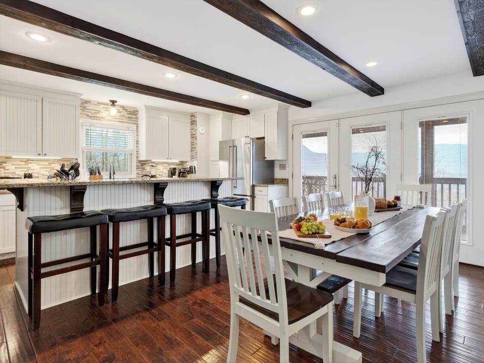 Dining area featuring a large wooden table and views of the deck.