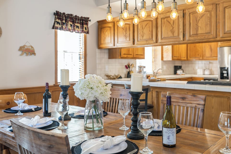Rustic dining area with a handcrafted wood table and statement chandelier, perfect for gathering after a day at the lake.