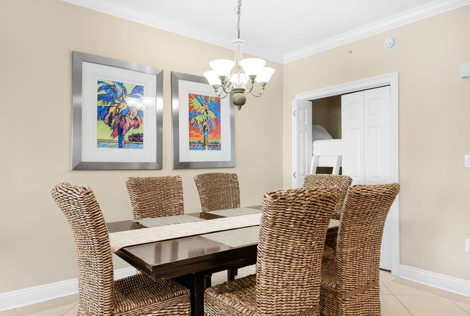 Gather around your elegant dining table where coastal artwork and warm lighting create the perfect ambiance for memorable meals together.