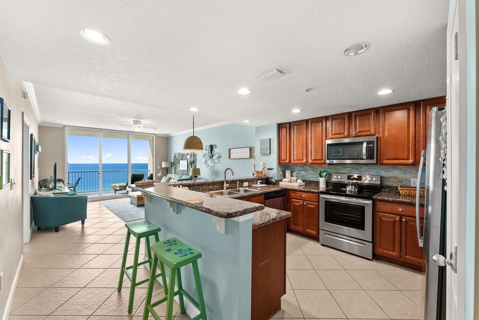 Your fully equipped kitchen flows seamlessly into the living area, where stunning ocean views greet you through expansive windows.