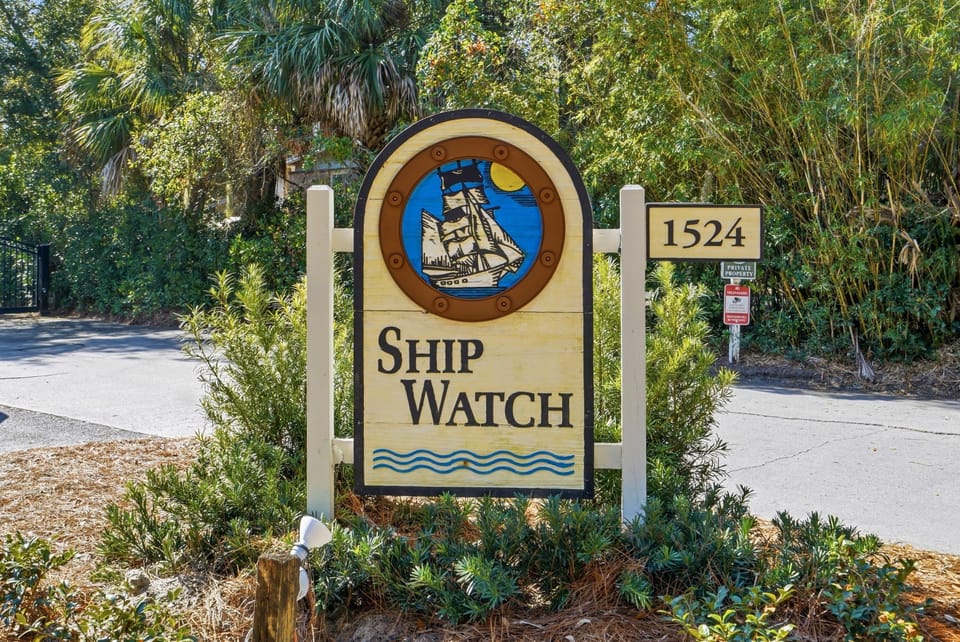 Shipwatch Entrance & Coastal Setting – Shipwatch 300 - Welcome to Shipwatch on East Beach, a gated coastal community surrounded by palms and just steps from the pool and beach access.