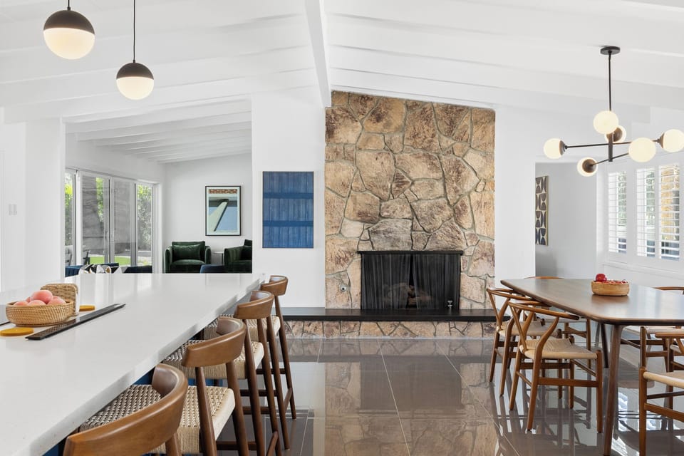 Unwind in this stunning open-plan space where modern design meets rustic charm. The stone fireplace creates warmth while sleek lighting illuminates your memorable gatherings.