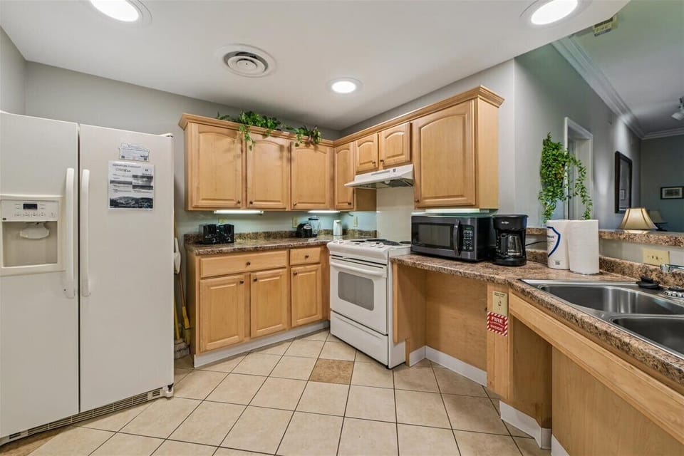 Your fully equipped kitchen awaits with granite countertops, modern appliances, and warm wood cabinets for memorable meal prep.