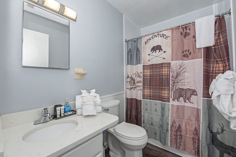 Refresh in your adventure-themed bathroom featuring a rustic woodland shower curtain and all the essentials for a comfortable stay.